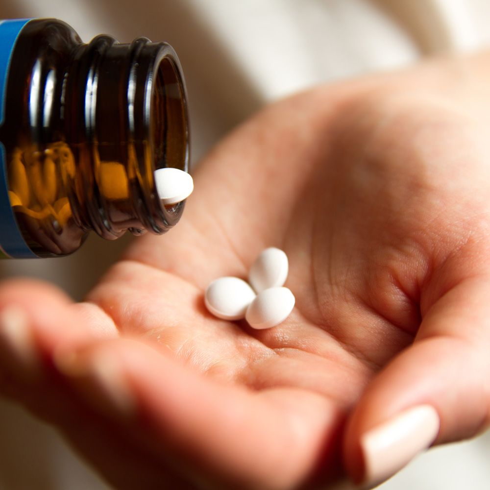 A man shakes pills from a bottle into his hand