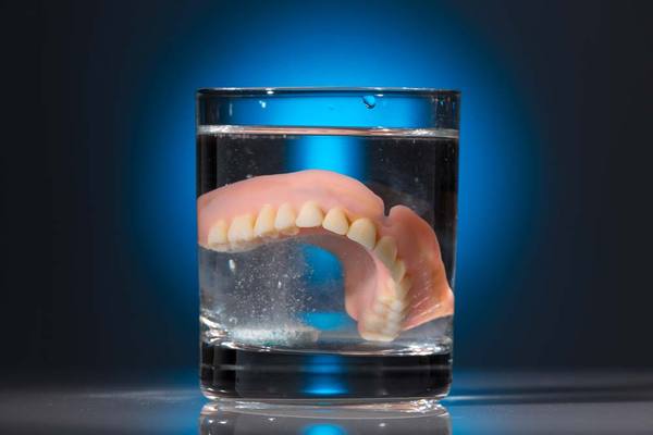 Denture soaking in glass of water